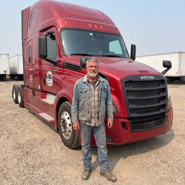 Truck driver standing with a Wheel Do It Logistics truck