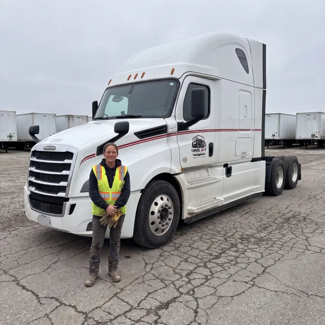 Truck driver standing with a Wheel Do It Logistics truck