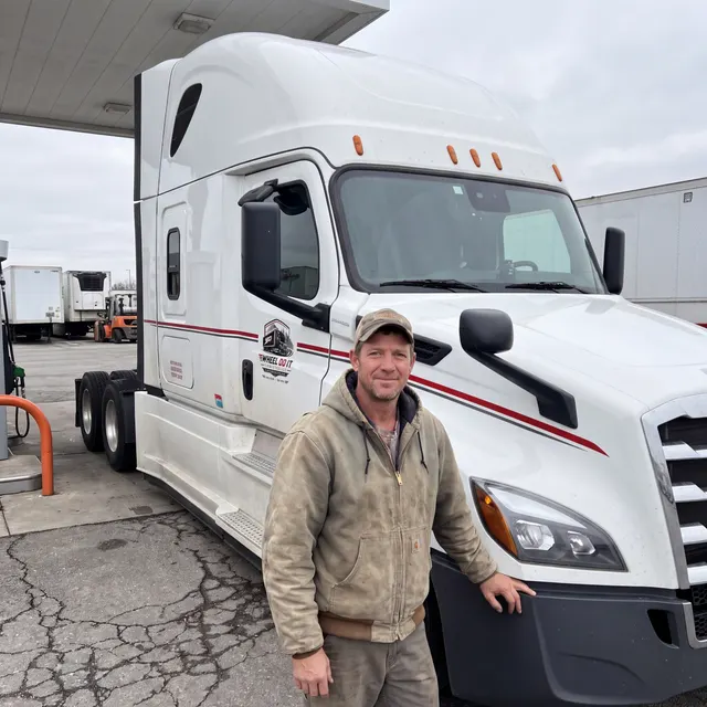 Truck driver standing with a Wheel Do It Logistics truck